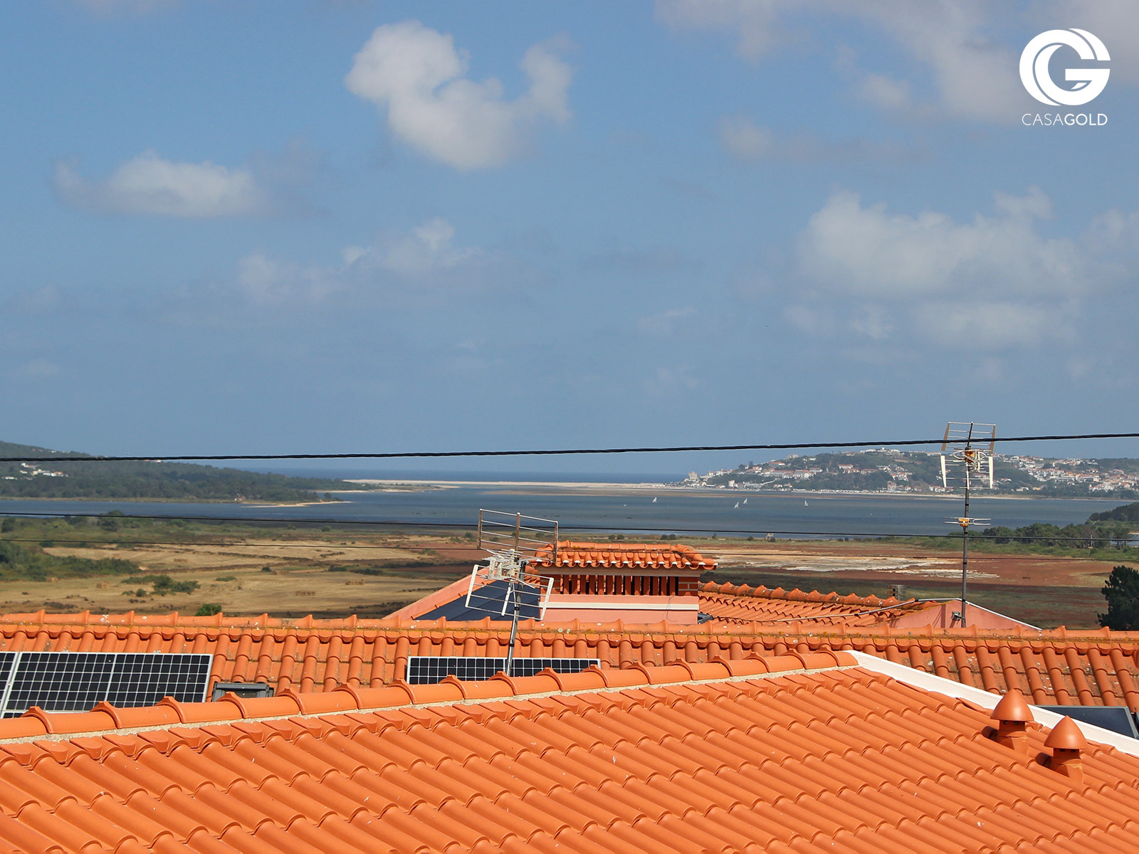 Vista panorâmica para a Lagoa de Óbidos, sobre os telhados do Arelho, num dia de céu azul